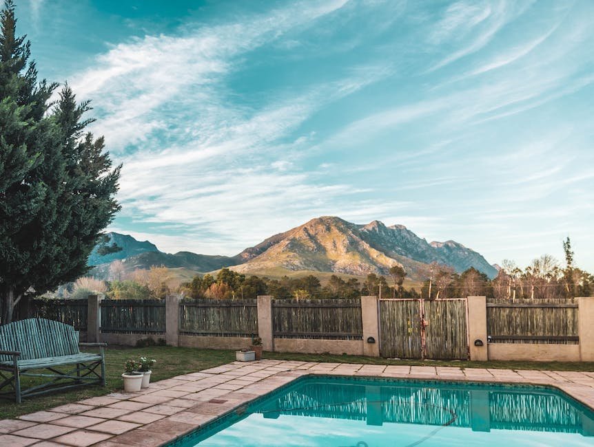 A tree with lush green leaves casting a nice shade over a beautifully landscaped backyard